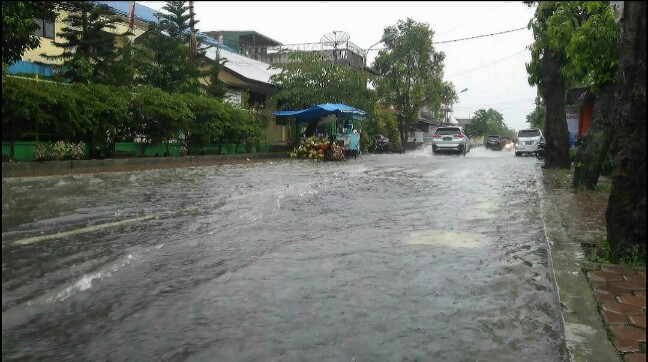 Genangan air melewati tinggi trotoar di Jalan Sibolga, Jumat sore (12/4/2019). (isiantar/nda).
