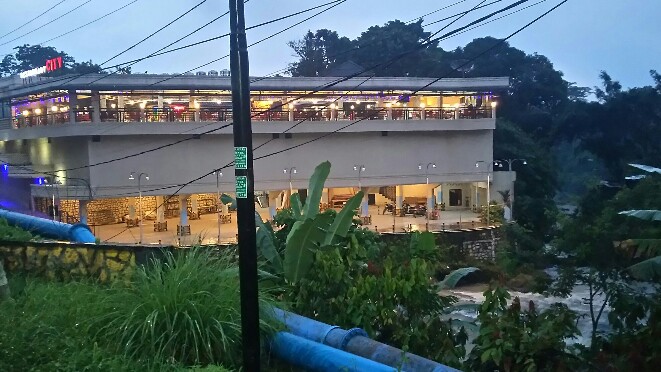 Aliran air sungai Bah Biak tampak mengalir di sisi kanan bangunan Studio Hotel & Restaurant City. (isiantar/nda).
