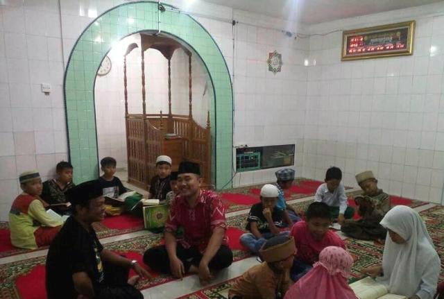Setiawan Gultom, berkemeja hitam, di tengah program Masjid ber Iqra.