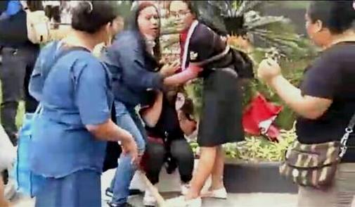 Seorang pedagang yang sempat mengalami trance setelah insiden dorong-dorongan dengan Satpol PP dicoba ditenangkan oleh teman-temannya.