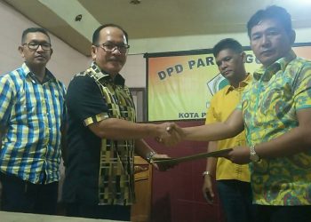 Ketua DPD Partai Golkar Mangatas Silalahi menyerahkan formulir pendaftaran bakal calon walikota kepada Asner Silalahi, Senin (11/11/2019). (isiantar/nda).