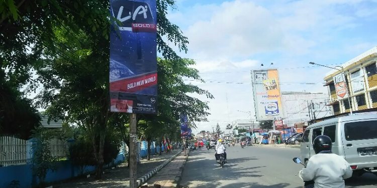 Deretan iklan produk rokok terpasang pada tiang-tiang lampu jalan di depan salah satu kampus di Jalan Sangnaualuh, Selasa (17/12/2019). (isiantar/nda).