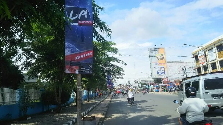 Deretan iklan produk rokok terpasang pada tiang-tiang lampu jalan di depan salah satu kampus di Jalan Sangnaualuh, Selasa (17/12/2019). (isiantar/nda).