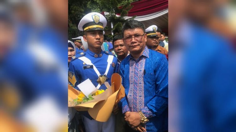 Maruba Sinaga dan putranya usai pelantikan Taruna Imigrasi tahun 2019, di Badan Pengembangan Sumber Daya Manusia (BPSDM) Hukum dan Hak Asasi Manusia, Jakarta, (9/12).