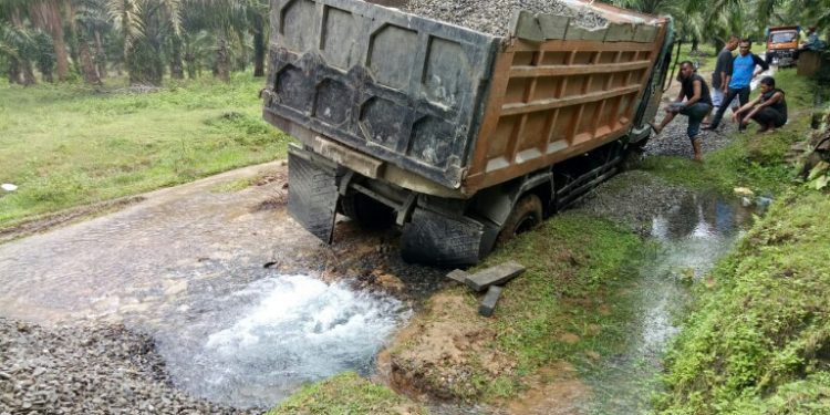 Truk pengangkut batu kerikil yang terperosok dan menyebabkan pipa distribusi PDAM Tirtauli patah, Kamis (19/12) pagi.