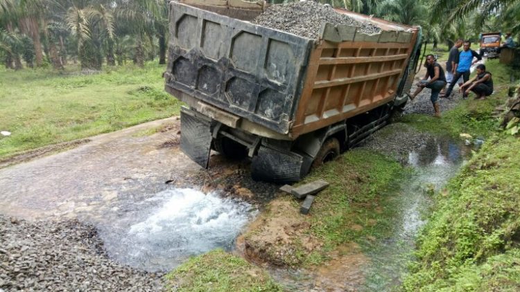 Truk pengangkut batu kerikil yang terperosok dan menyebabkan pipa distribusi PDAM Tirtauli patah, Kamis (19/12) pagi.