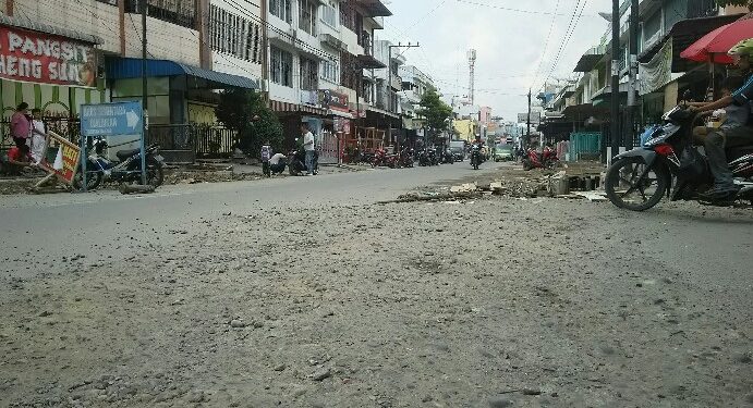 Material batu kerikil yang terkelupas dari aspal akibat penggalian proyek drainase berserakan di atas badan Jalan Wahidin, Selasa (14/1/2010). (isiantar/nda).