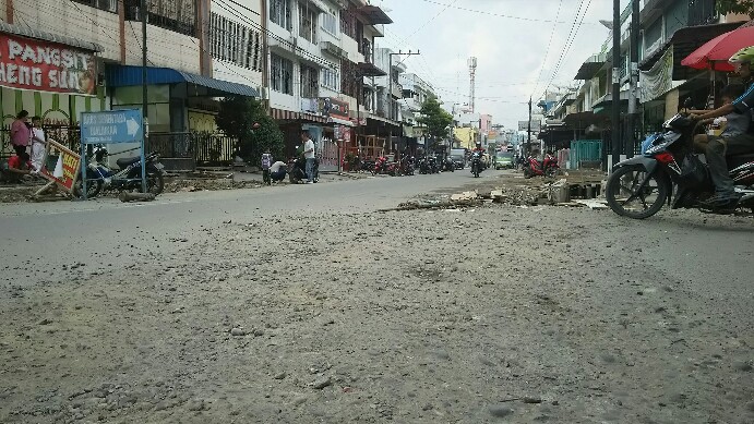 Material batu kerikil yang terkelupas dari aspal akibat penggalian proyek drainase berserakan di atas badan Jalan Wahidin, Selasa (14/1/2010). (isiantar/nda).