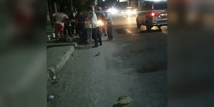 Warga berkerumun menolong pengendara yang terjatuh setelah menabrak material proyek yang berada di badan Jalan Asahan, Jumat malam (9/1/2020).