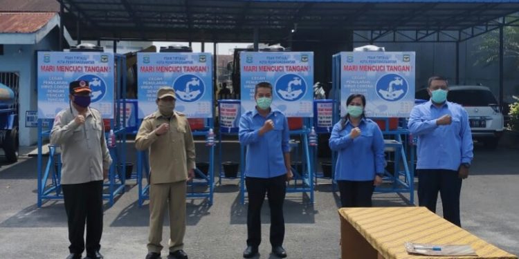 Pj Sekda Kusdianto dan Ketua Gugus Tugas Covid-19 Midian Sirait foto bersama dengan jajaran direksi PDAM Tirtauli usai penyerahan bantuan untuk pencegahan wabah Covid-19, di halaman PDAM Tirtauli, Senin pagi (20/4/2020).