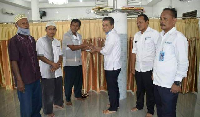 Direktur Utama PDAM Tirtauli Zulkifli Lubis saat menyerahkan bantuan kepada pengurus masjid.