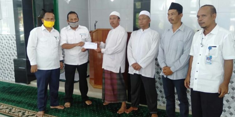 Ketua Ketua Panitia Ramadhan Berbagi PDAM Tirtauli Ikhwan Lubis menyerahkan bantuan kepada pengurus Musholla Al Ikhlas yang beralamat di Huta 2 Nagori Karang Sari, Kecamatan Gunung Maligas, Kabupaten Simalungun, Selasa (5/5/2020).
