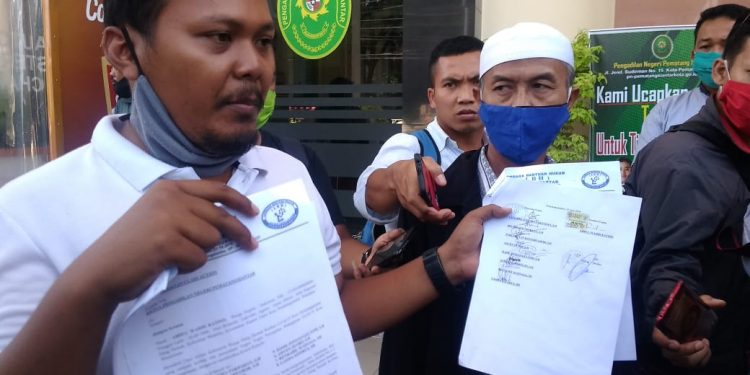 (Kiri) Pengacara LBH Pematangsiantar Chandra Kusuma Pakpahan, didampingi warga Gang Demak Abdul Wahid Katino (kanan) usai melegalisir gugatan di PN Pematangsiantar, Senin (29/6) siang.
