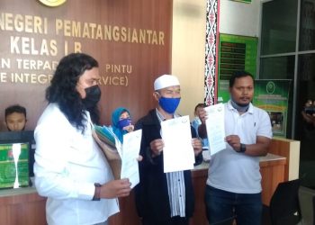 (Tengah) Abdul Wahid Katino, salah seorang warga Gang Demak yang menggugat Ketua GTPP Hefriansyah Noor, diapit dua orang kuasa hukumnya dari LBH Pematangsiantar, usai melegalisir gugatannya di PN Siantar, Senin (29/6/2020).