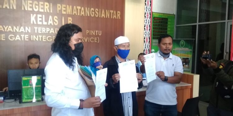 (Tengah) Abdul Wahid Katino, salah seorang warga Gang Demak yang menggugat Ketua GTPP Hefriansyah Noor, diapit dua orang kuasa hukumnya dari LBH Pematangsiantar, usai melegalisir gugatannya di PN Siantar, Senin (29/6/2020).