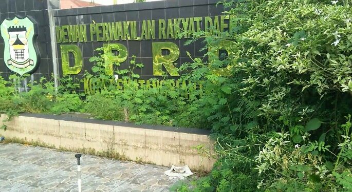 Penampakan taman dan kolam hias DPRD Siantar di Jalan Adam Malik, yang tak hanya disesaki belukar dan sampah namun juga dipenuhi botol-botol minuman, Kamis (9/7). (isiantar/nda).