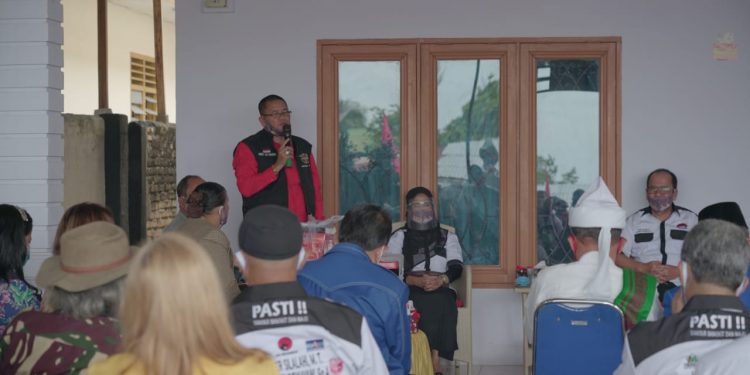 Ferry SP Sinamo, berdiri mengenakan kemeja merah dengan rompi hitam. (Dok/PASTI).