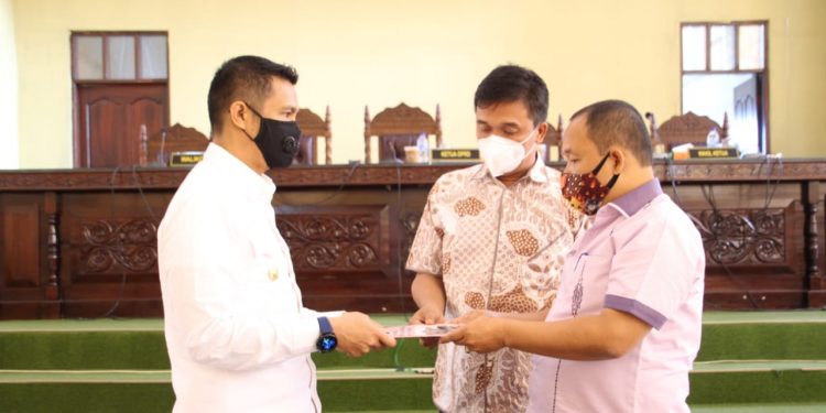 Ketua DPRD Kota Siantar, Timbul Lingga, menyerahkan berita acara Perda Perumda Air Minum Tirtauli kepada Walikota Siantar, Hefriansyah, Selasa (27/10).