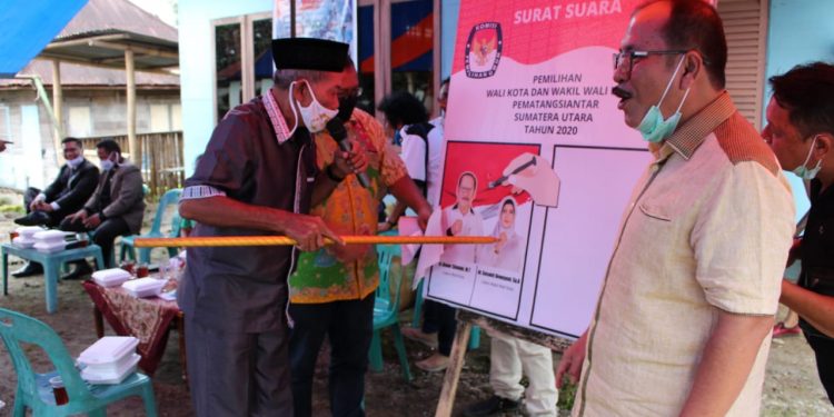 Salah seorang tokoh masyarakat melakukan simulasi Mencoblos Calon Walikota dan Wakil Walikota Pematangsiantar Ir Asner Silalahi MT - dr Susanti Dewayani SpA pada kertas suara untuk Pilkada 9 Desember 2020.