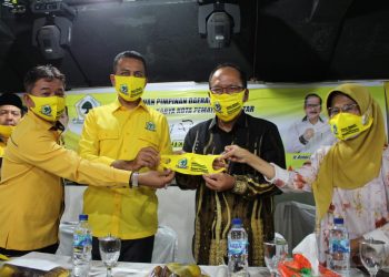 Drs H Musa Rajekshah M.hum dan Mangatas Silalahi menyerahkan masker Golkar kepada Ir Asner Silalahi Mt bersama dr Susanti Dewayani SpA.
