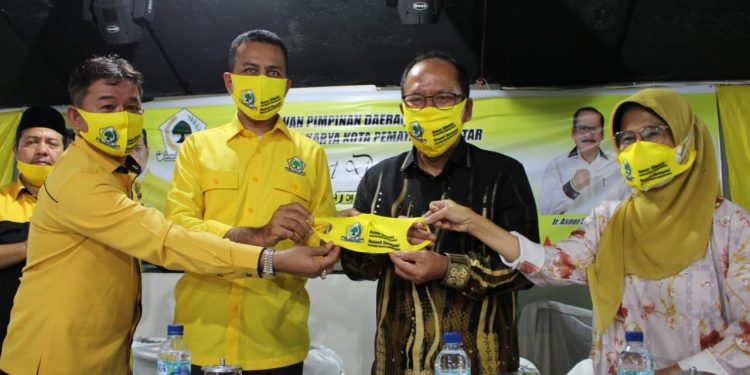 Drs H Musa Rajekshah M.hum dan Mangatas Silalahi menyerahkan masker Golkar kepada Ir Asner Silalahi Mt bersama dr Susanti Dewayani SpA.