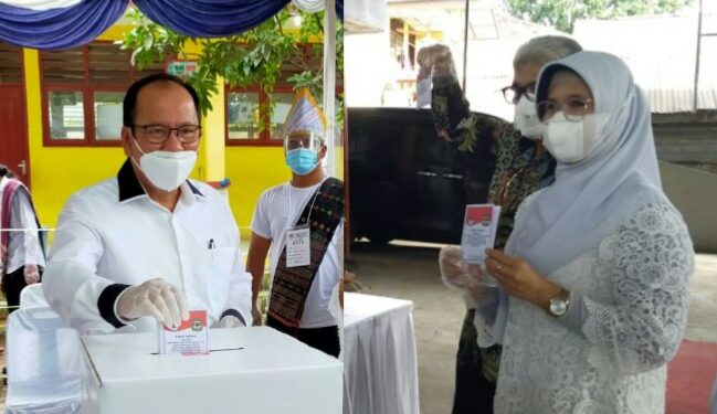 Asner Silalahi (kiri), Susanti Dewayani (kanan), saat menggunakan hak suara mereka di TPS, Rabu (9/12/2020).