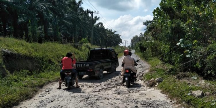 Tiga unit kendaraan tampak sedang berjuang melintasi salah satu ruas jalan yang rusak di Kabupaten Simalungun, Sabtu (27/2) siang. (isiantar/Us).