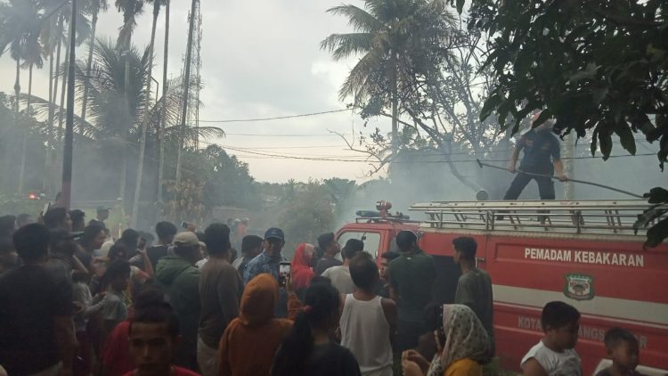 Kerumanan warga tengah menyaksikan upaya pemadaman api kebakaran oleh Damkar Siantar, Jumat (5/3) sore. (isiantar/jw-NM).