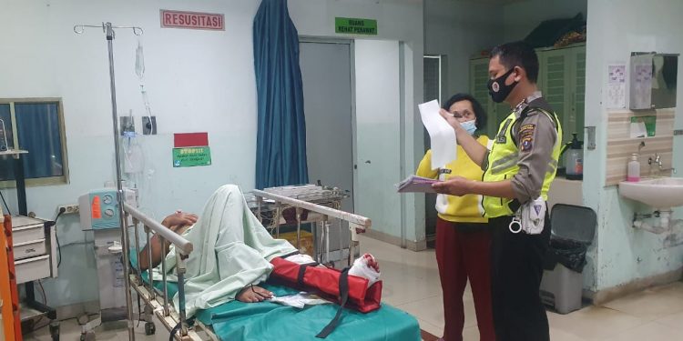 Salah seorang pengendara tampak terbaring di rumah sakit usai terkapar di atas aspal akibat kecelakaan di Asahan dekat Kompleks Megaland, Selasa (20/4) pagi.