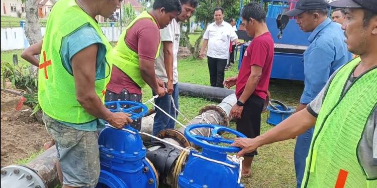 (Tengah, mengenakan kemeja putih) Plt. Dirut Perumda Tirta Uli, Arianto ST, sedang memimpin langsung proses pemasangan meter induk di reservoir Perumda Tirta Uli, di Simpang Panei, Rabu (18/10/2023). (isiantar/nda).