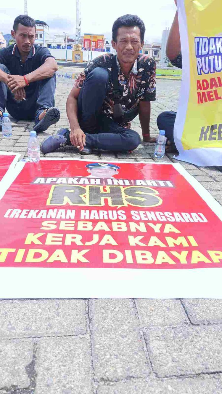 Salah seorang pengunjuk rasa dengan poster yang dibawanya.