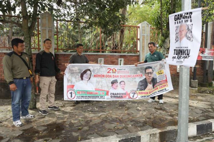 (Kanan) Kepala Satpol PP Kota Pematang Siantar, Pariaman Silaen, bersama sejumlah personil Satpol PP, tengah melakukan penertiban terhadap poster dan spanduk peserta pemilu yang diresahkan masyarakat karena dinilai merusak wajah kota.