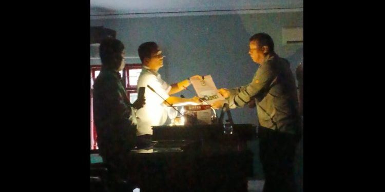 Prosesi penyerahan Hasil Pembahasan Panitia Khusus DPRD Siantar, oleh ketua Pansus, Tongam Pangaribuan, kepada Pimpinan DPRD, Daud Simanjuntak, hanya menggunakan pencahayaan dari telepon genggam, Jumat (13/2/2026).